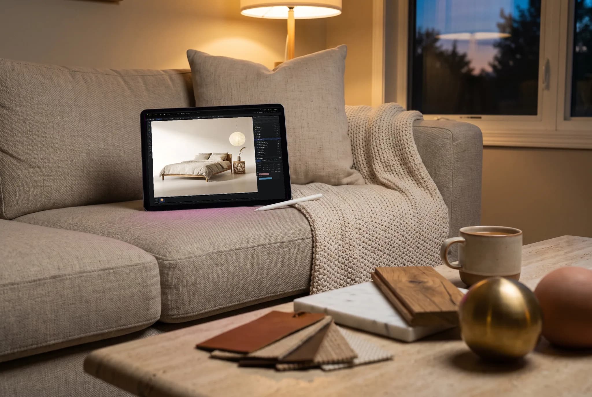 mixos Studio open on an iPad showing a low oak bed made up in oatmeal linen beside a paper globe lamp, propped against a cushion on a sofa in warm evening lamplight.